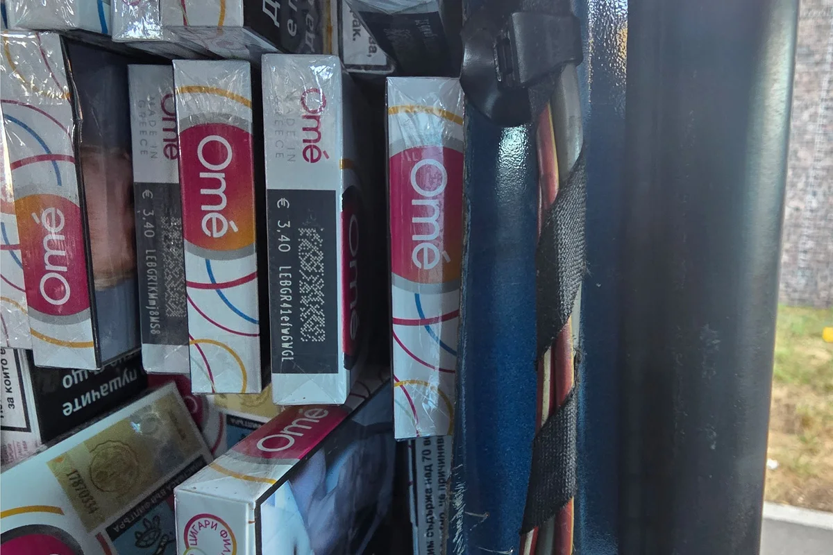 Mehrere Zigarettenpackungen befinden sich in einem Automaten, erkennbar an den Markenaufdrucken und Preisschildern. Das Bild zeigt Details von Plastikfolien und Etiketten.
