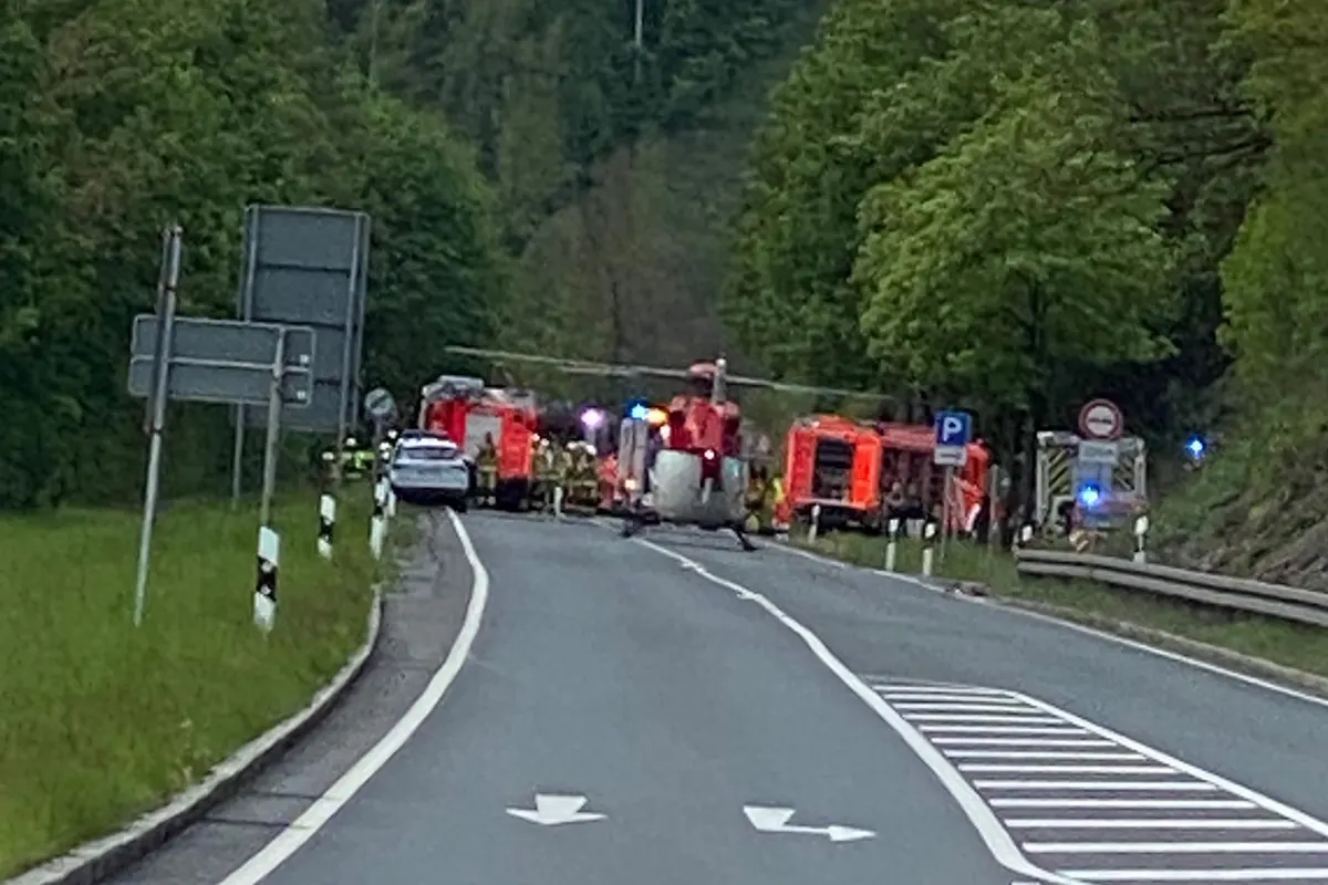 Mehrere Einsatzfahrzeuge und ein Hubschrauber sind auf einer Landstraße zu sehen. Die Straße scheint gesperrt zu sein und es sind Rettungskräfte anwesend.