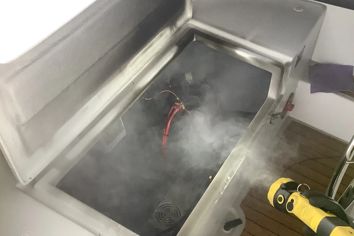 Ein Boot zeigt Rauchentwicklung in einem offenen Bereich, daneben ist ein Feuerwehrgerät sichtbar. Es deutet auf einen möglichen technischen Defekt hin.