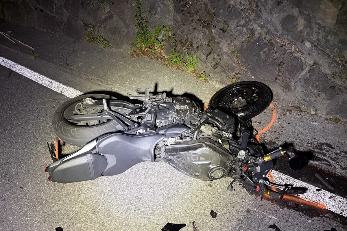 Ein Motorrad liegt umgestürzt auf einer asphaltierten Straße neben einer Steinmauer. Der Unfall ereignete sich nachts.