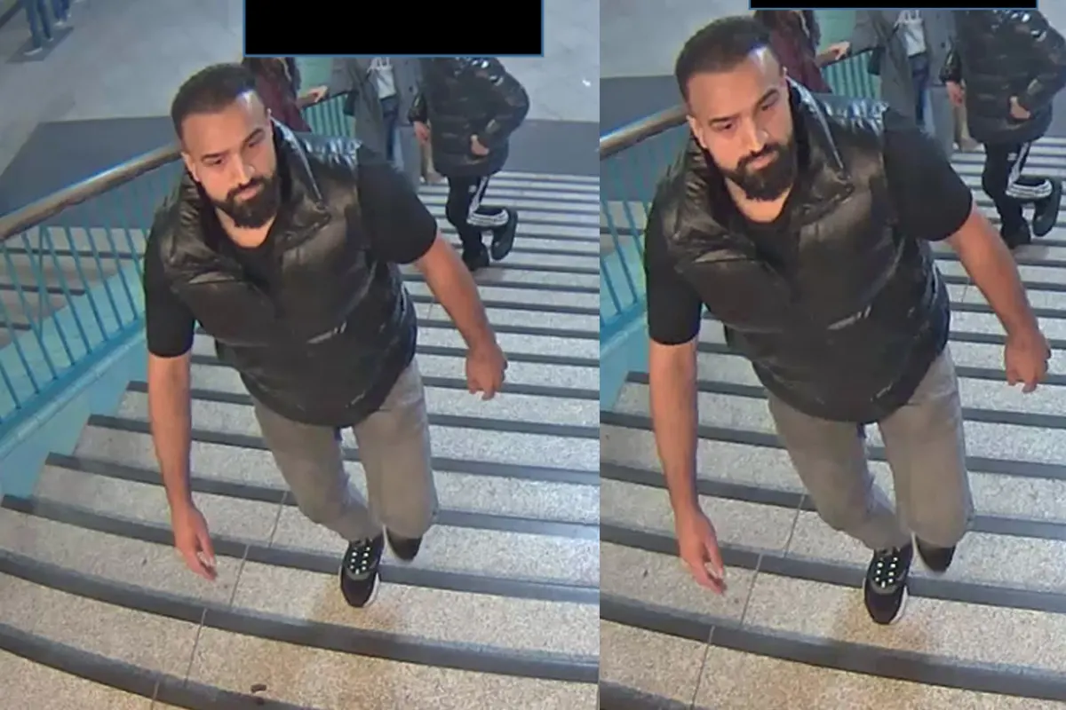 Ein Mann mit Bart und schwarzem Oberteil wird von einer Überwachungskamera erfasst, während er eine Treppe hochsteigt.