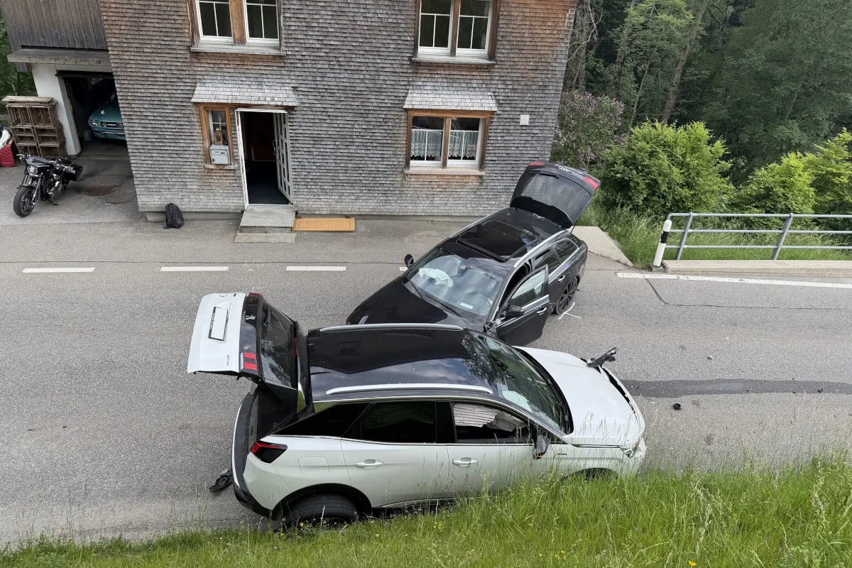 Zwei Autos sind auf einer Straße miteinander kollidiert und stehen vor einem Wohnhaus. Beide Autos haben ihre Kofferräume geöffnet.