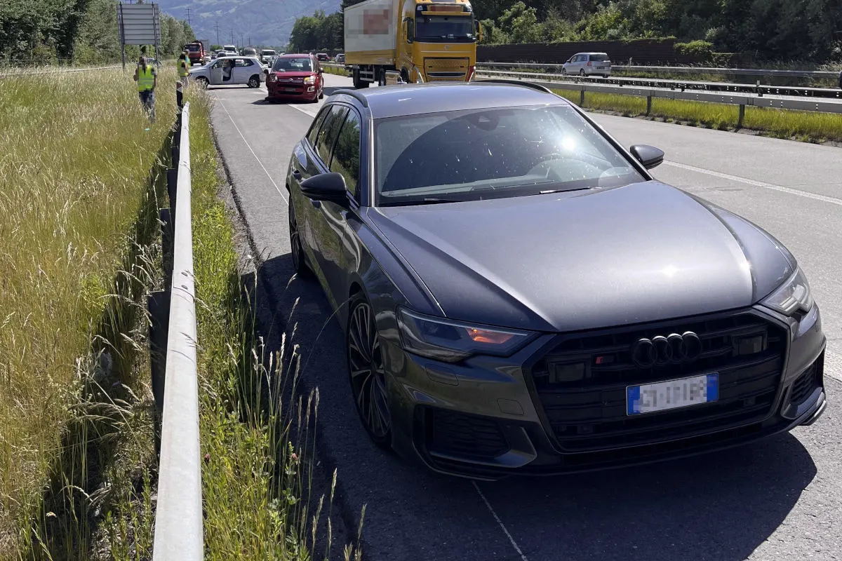Ein schwarzer Audi steht auf einer Landstraße. Im Hintergrund sind weitere Fahrzeuge, darunter auch ein Lkw, zu sehen.