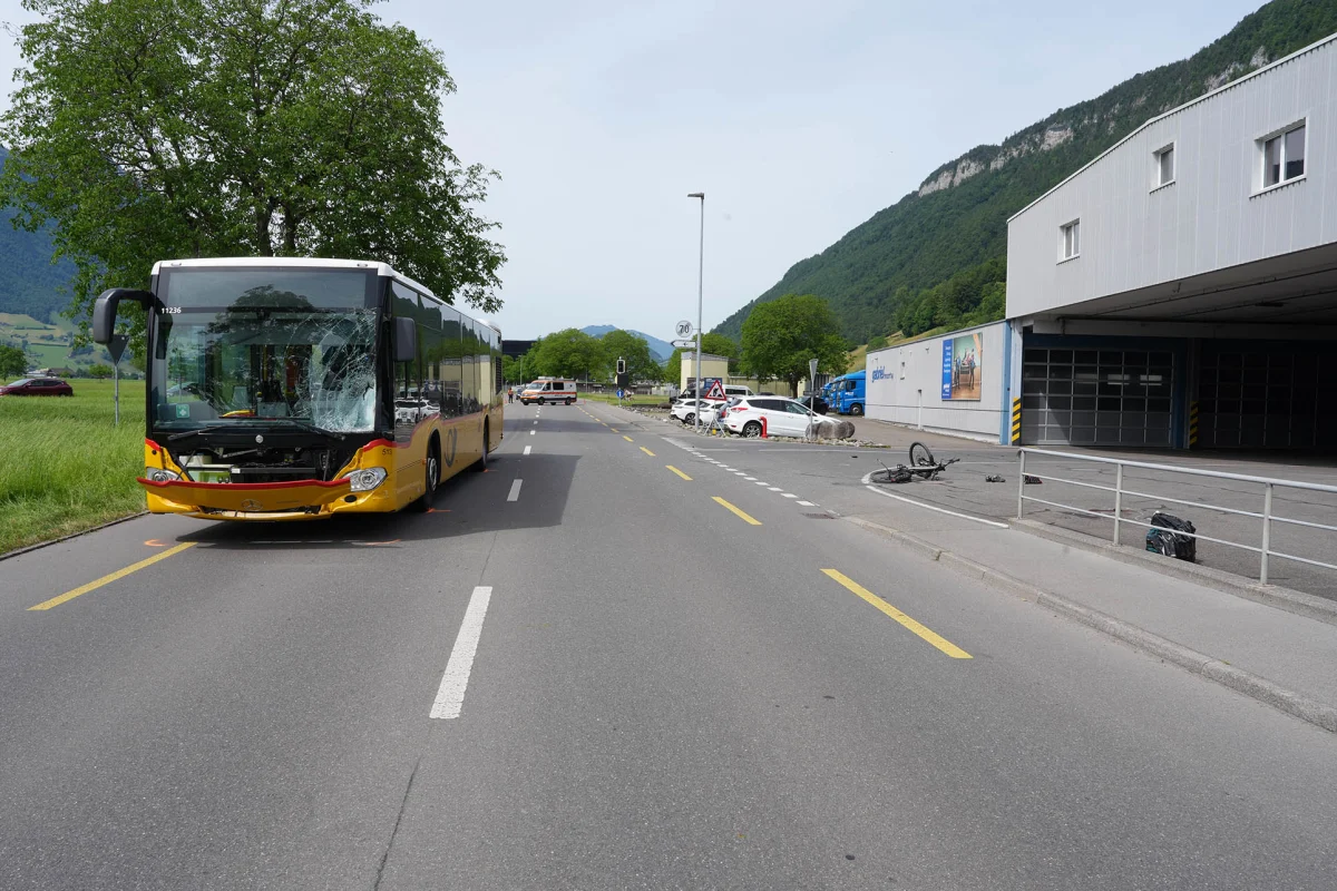 Ein großer, gelber Bus mit beschädigter Windschutzscheibe steht auf einer Landstraße. Rechts ein Fahrrad neben einer Parkbucht.