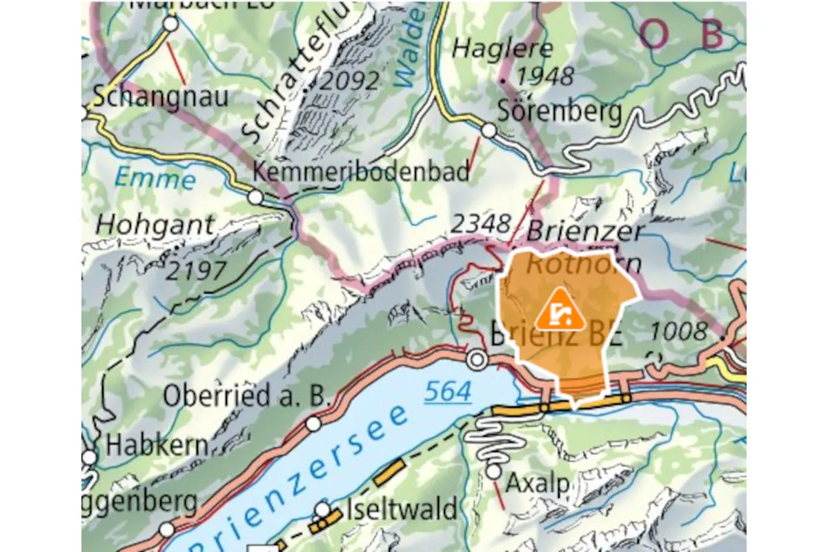 Eine Landkarte zeigt das Gebiet rund um Brienz BE mit einem orange markierten Bereich und einem Warnsymbol, das auf einen Erdrutsch hinweist.