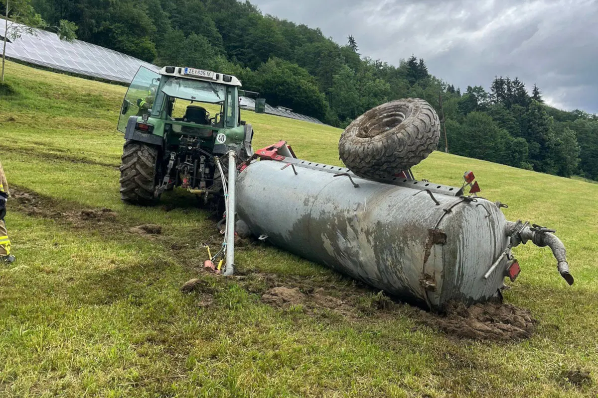 Ein umgekippter Güllewagen liegt auf einer Wiese, neben einem grünen Traktor. Ein Rad liegt auf dem Wagen.