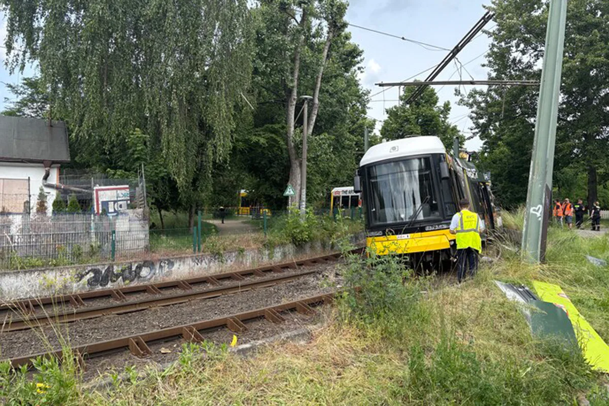 Eine gelb-schwarze Straßenbahn ist entgleist und steht neben den Gleisen. Personen in Warnwesten sind vor Ort.
