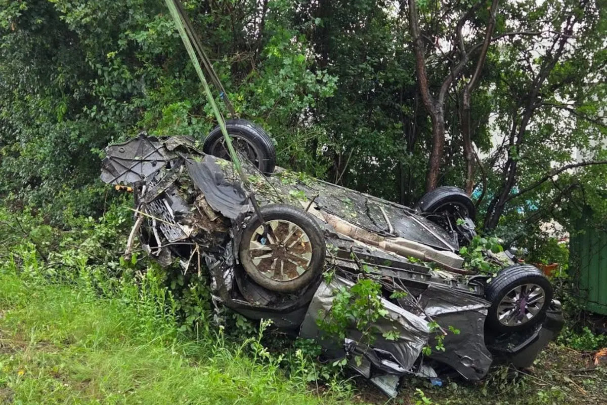 Ein stark beschädigtes Auto liegt auf dem Dach inmitten von dichtem Gebüsch. Die Vegetation deutet auf ländliche Umgebung hin.