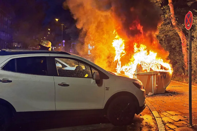 München BY – Beschädigte Fahrzeuge durch Brand von Glascontainer 