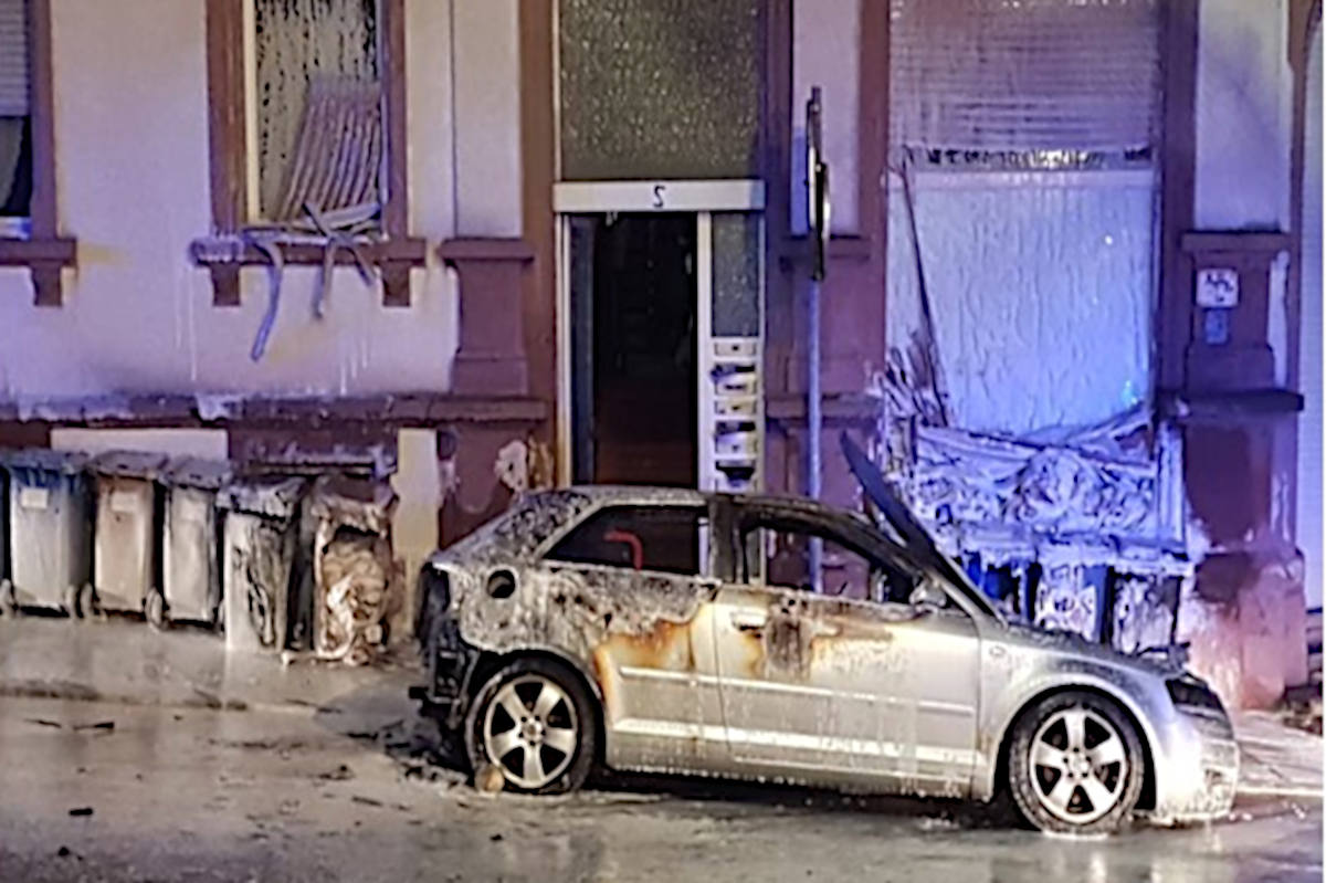 Ausgebranntes Fahrzeug und beschädigte Fassade