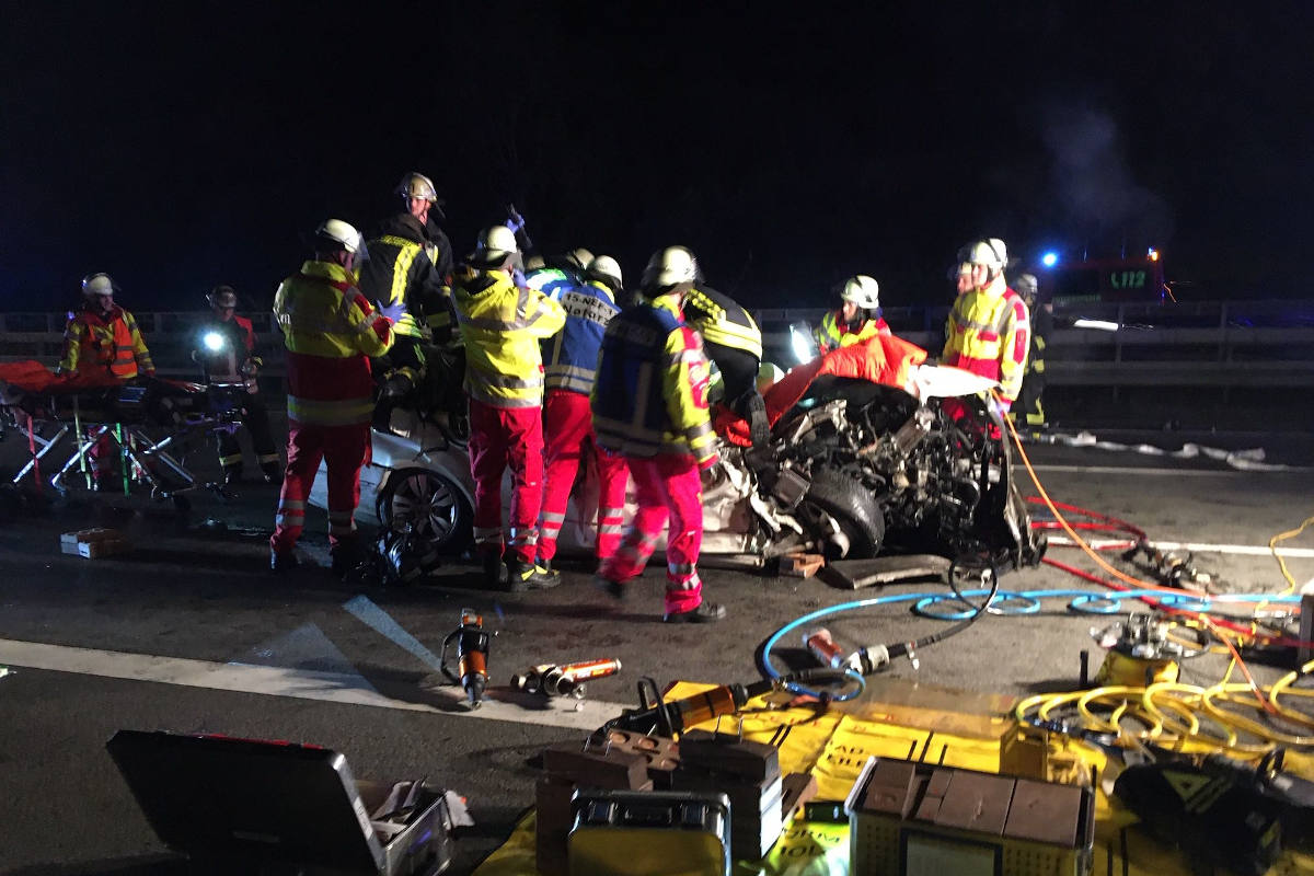 Einsatzkräfte befreien den eingeklemmten Beifahrer aus dem Fahrzeug