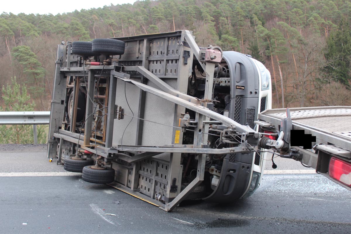 Durch den Aufprall kippte der Anhänger mit einem darauf transportierten Ford Transit um und kam auf der Seite liegend zum Stillstand