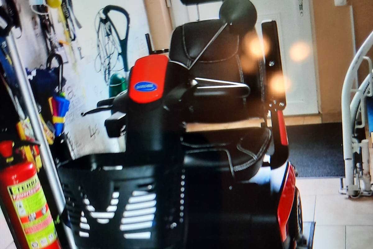 Der Mann ist mit einem schwarz-rotem Elektrorollstuhl der Marke "Orion" unterwegs