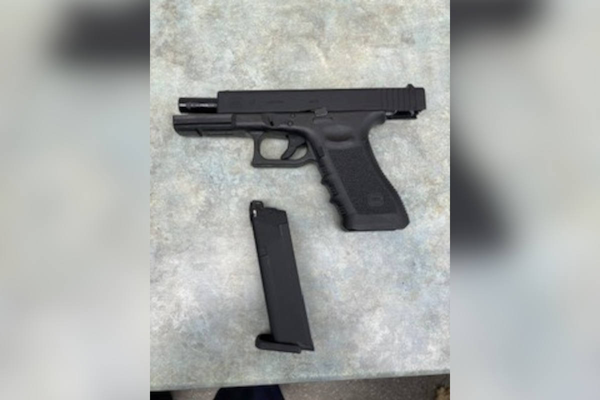 Mann mit Schild, Schussweste und Softair-Pistole in einem Cafe