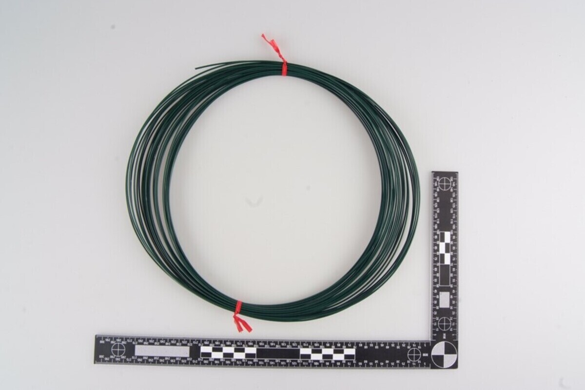 Grüner Gartendraht, mit dem blaue Tragegriffe an der Leiche befestigt waren