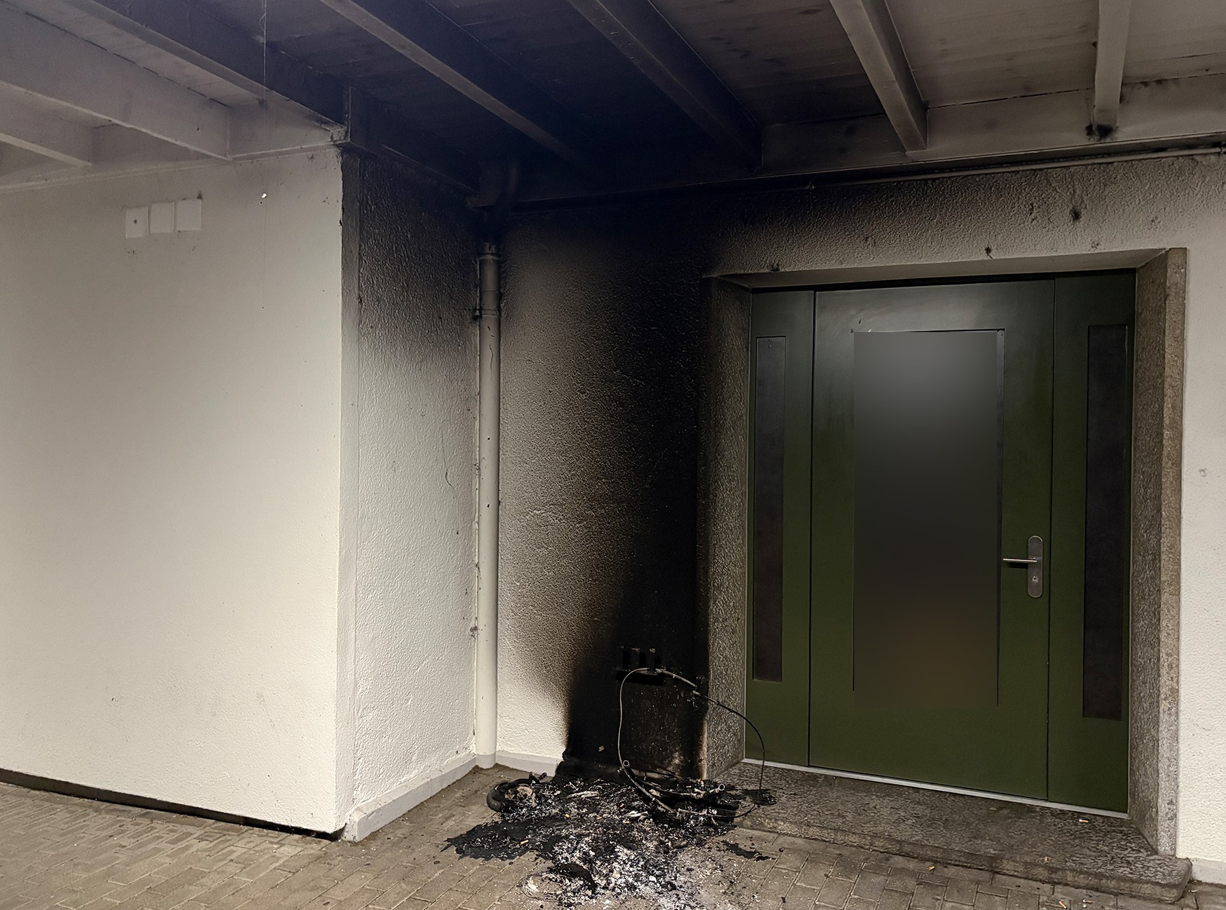 Verbrannte Wand und Tür mit Russspuren nach einem Brand