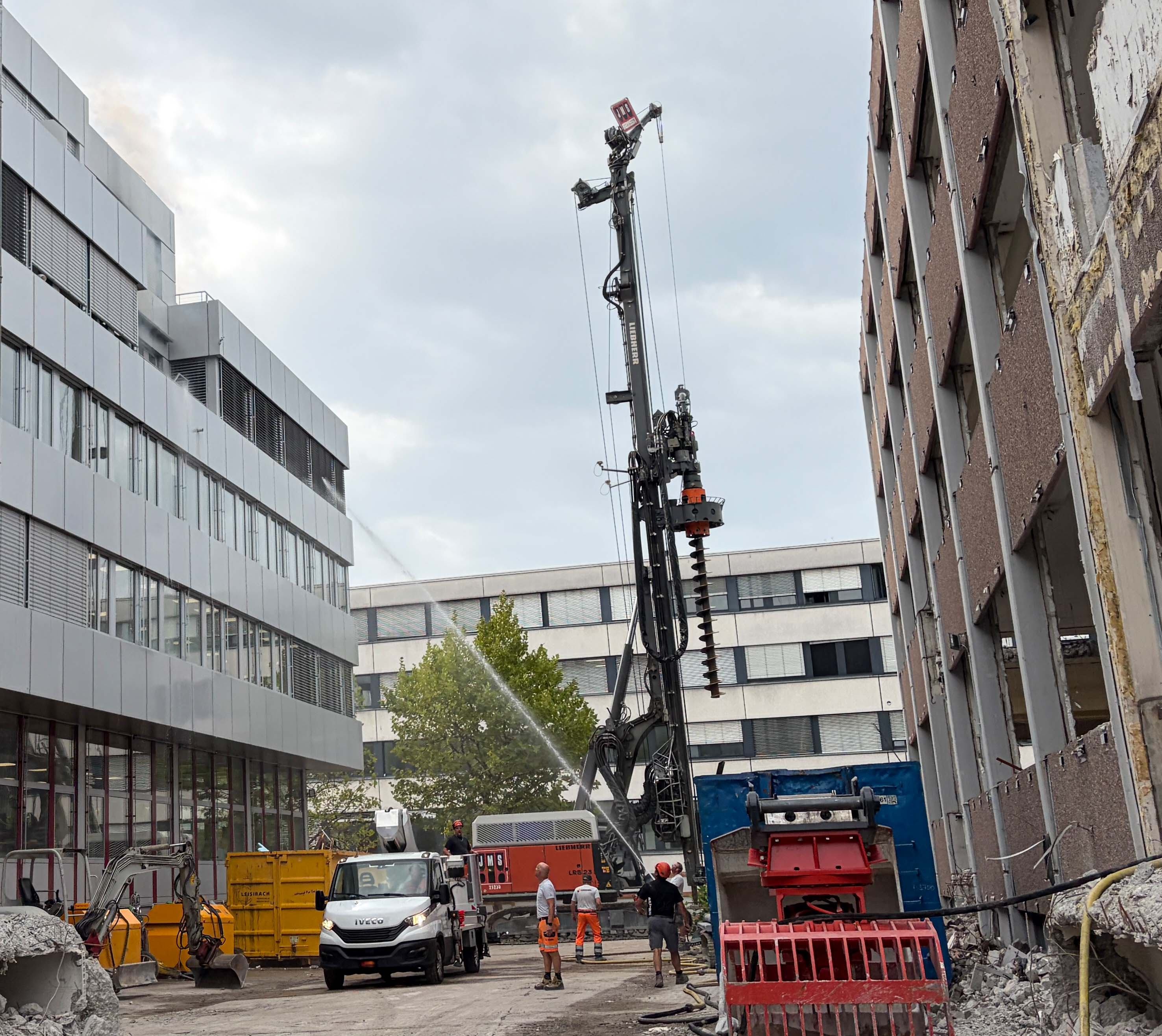 Arbeiter bekämpfen den Balkonbrand mit einem Wasserschlauch