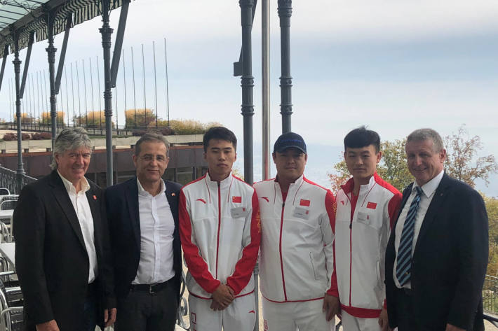 Die Projektverantwortlichen mit drei chinesischen Eishockeyspielern.