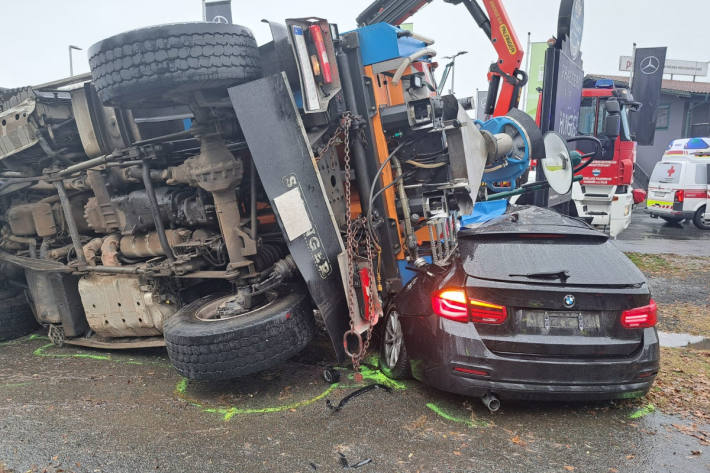 Die Zugmaschine kippte auf den Pkw und klemmte den Pkw-Lenker ein.