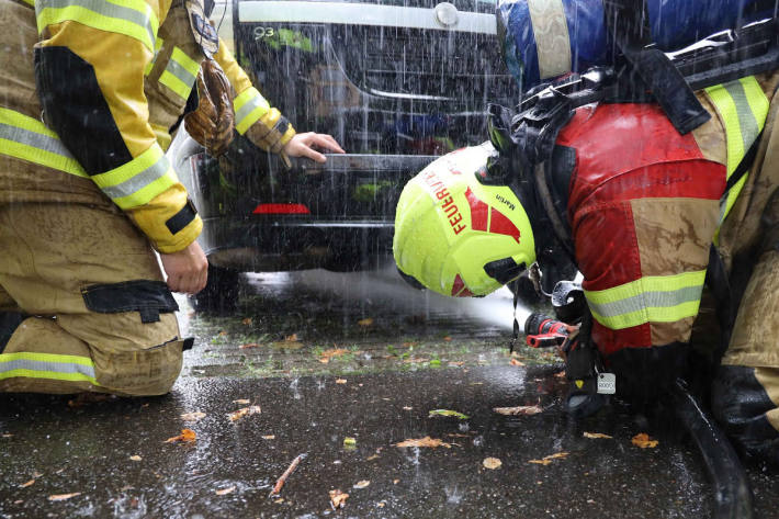 Polizist und Feuerwehr löschen Fahrzeugbrand