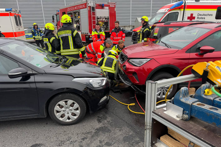 Eine Frau wurde unter einem Auto eingeklemmt.
