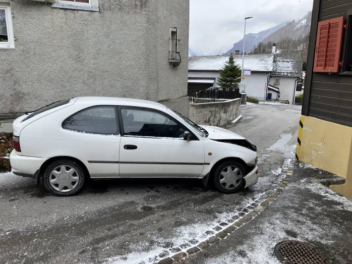 Junglenker prallt auf schneebedeckter Strasse in Hauswand