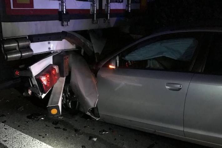 Verunfallter PKW unter dem LKW.