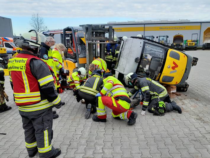 Person unter Bagger eingeklemmt