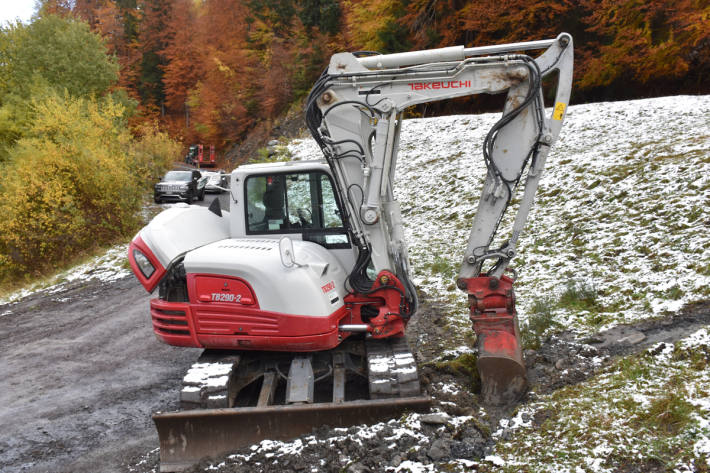 Der beschädigte Raupenbagger mit dem beschädigten Traktor im Hintergrund