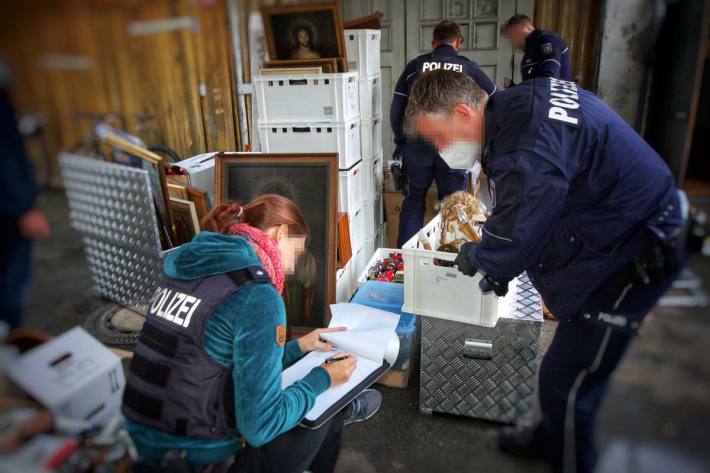 Kistenweise trugen die Einsatzkräfte Beweismittel aus den Häusern