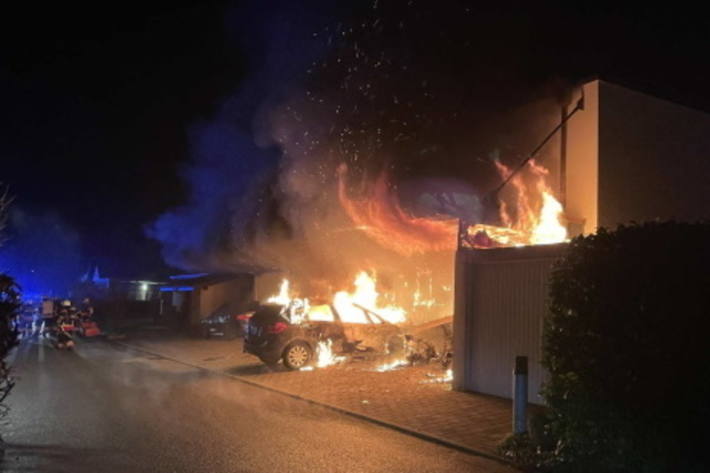 Ein Unterstand und drei Fahrzeuge in Brand