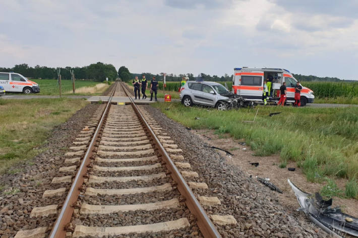 Seniorin fährt mit Pkw in fahrenden Personenzug