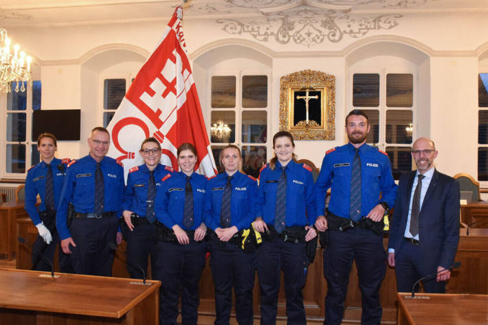 Von links: Kpl Selin Schenker (Fahne), Maj Stefan Küchler, Polizeikommandant, Wm Elisabeth Nufer, Pol Jasmin Barmettler, Pol Mirja Huser, Pol Sandra Rohrer, Pol Timon Burch, Regierungsrat Christoph Amstad, Vorsteher Sicherheits- und Sozialdepartement