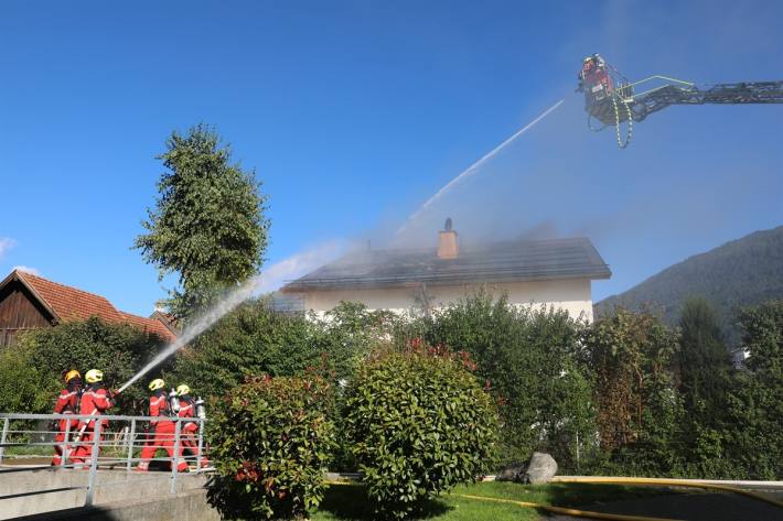 Einsatzkräfte löschen den Dachbrand
