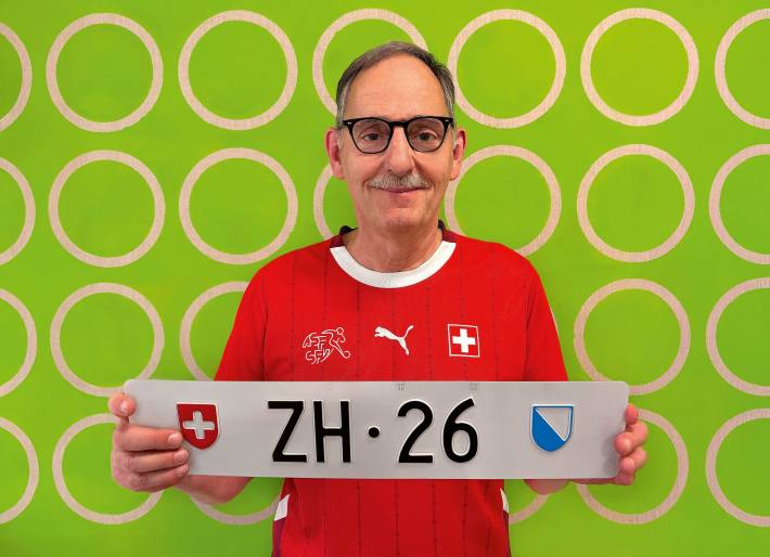 Regierungsrat Mario Fehr präsentiert das ZH-Nummernschild als Symbol für das ereignisreiche Sportjahr 2026