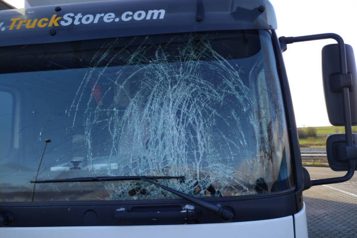 Zerstörte Windschutzscheide eines von einer Eisplatte getroffenen LKW