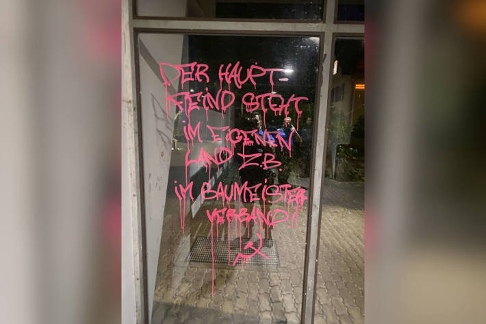 Glaswand und Fassade besprayt durch Vandalen