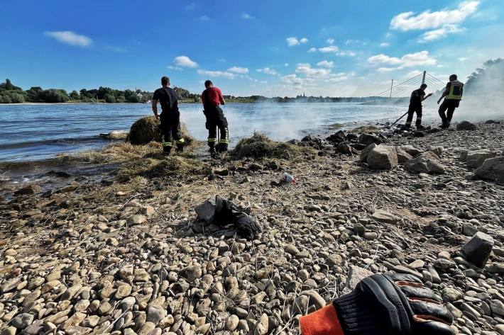 Heuballen brennt mitten im Rhein