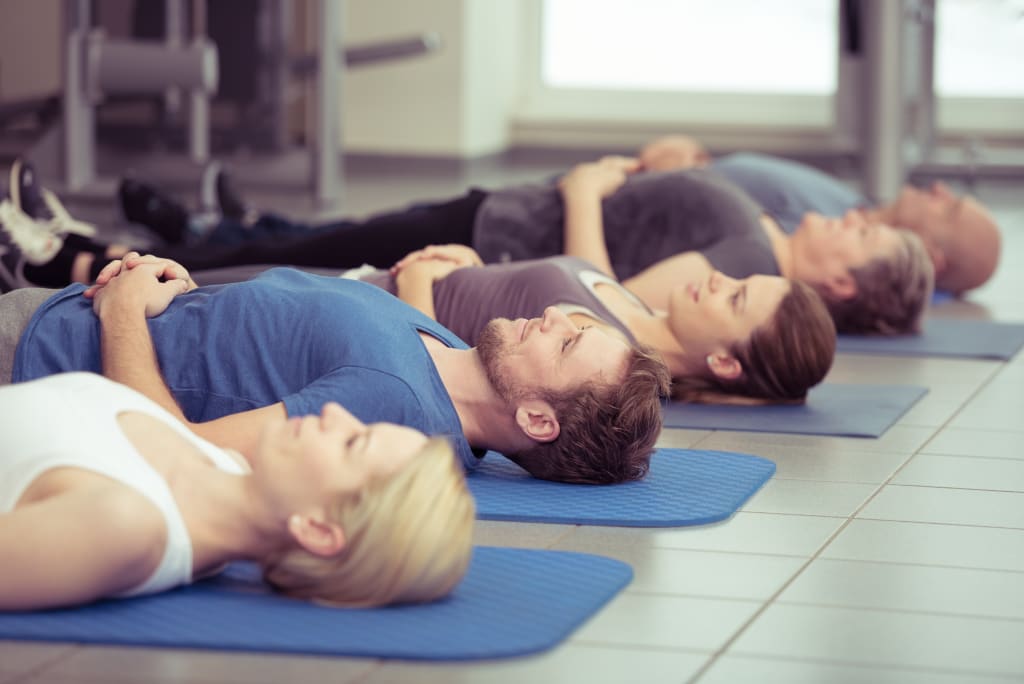 Männer und Frauen praktizieren Entspannungsübungen. (Foto: pro psychotherapie e.V./contrastwerkstatt)