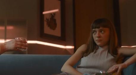 Der allgegenwärtige Alkohol in der Phantastik. Szene aus dem Trailer zur Serie "Bodies". Rechts sitzt die Ermittlerin aus der Zukunfts-Handlung auf einer Couch, links von ihr ihre Nachbarin,  mit einem Glas Alkohol in der rechten Hand, bereit anzustoßen.