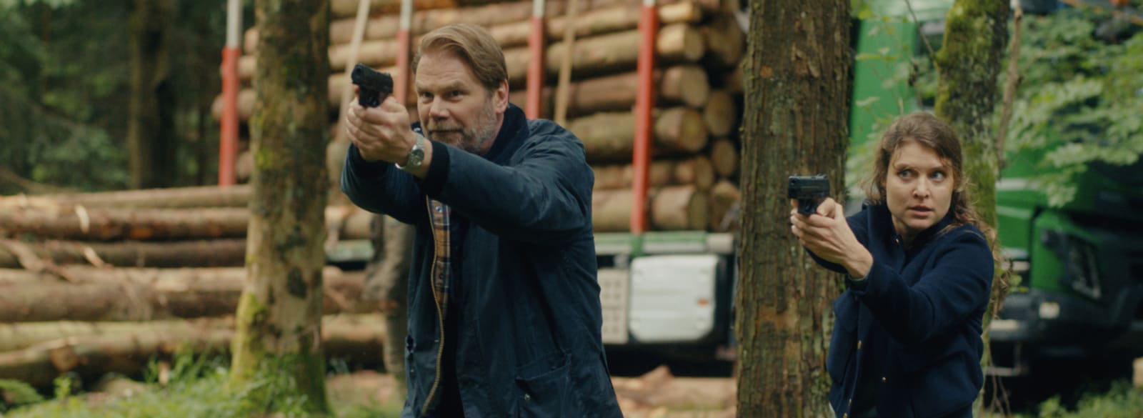 Die Ermittler Robert Winkler (Kai Scheve) und Karina Szabo (Lara Mandoki) mit gezückter Waffe im Holzlager.
