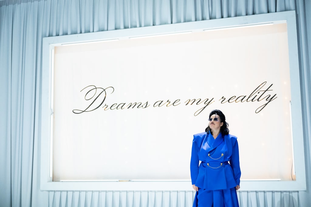 Katja Jung als Moshammer vor dem Schriftzug "Dreams are my reality"