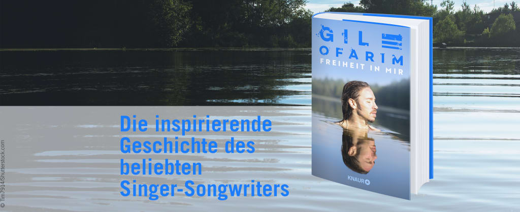 See mit klarem Wasser im Hintergrund, im Vordergrund das Buch "Freiheit in mir" von Gil Ofarim und der Text "Die inspirierende Geschichte des beliebten Singer-Songwriters"