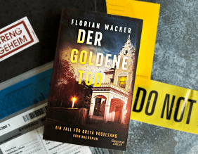 Foto vom Buch "Der goldene Tod" von Florian Wacker, Buch liegt auf einem Beweismittelbeutel und einem Crime Scene Band