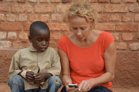 Katja Riemann zeigt einem kleinen Jungen ihr Smartphone