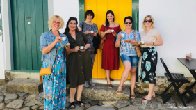 Sechs Frauen vor einer bunten Tür mit Kaffee