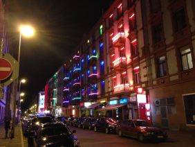 Straße bei Nacht mit beleuchteten Balkonen
