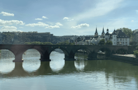 Das Foto zeigt den Ausblick auf Koblenz vom Wasser aus. Es zeigt eine Brücke und Kirchtürme im Hintergrund.