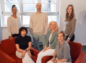 Ein Gruppenfoto von sechs Personen, die für ein gemeinsames Foto posieren.