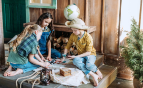 Kinder sitzen und basteln im Freien